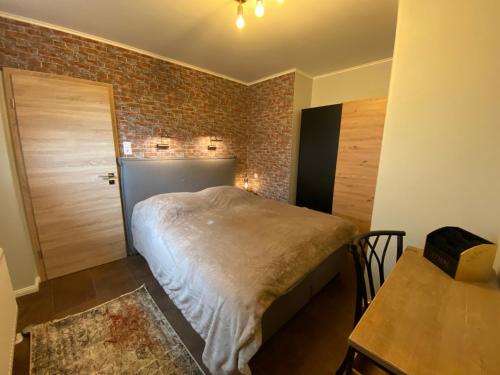 ein Schlafzimmer mit einem Bett und einer Ziegelwand in der Unterkunft Magnus & Morgentau in Göhren