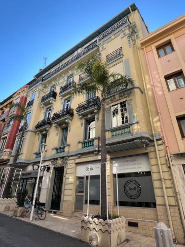 un bâtiment avec un palmier devant dans l'établissement Charming Sunny Apartment across Monte Carlo Casino, à Beausoleil