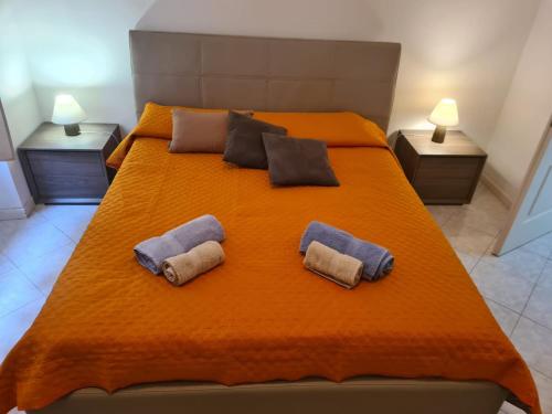 ein großes orangenes Bett mit zwei Kissen darauf in der Unterkunft Case Del Festival in Sanremo