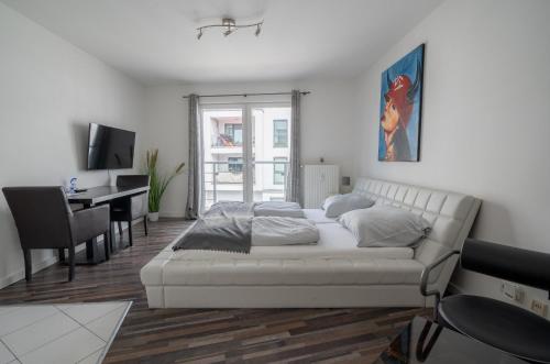- une chambre blanche avec un lit et un bureau dans l'établissement My Apartment im Bremer Viertel, à Brême