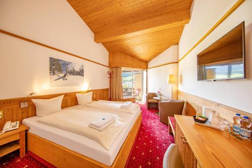 T3 Alpenhotel Flims في فليمس: غرفة نوم بسرير كبير في غرفة