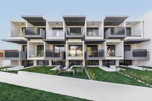 an apartment building with balconies and a yard at Calm Chaos studio 1 in Kallithea Halkidikis