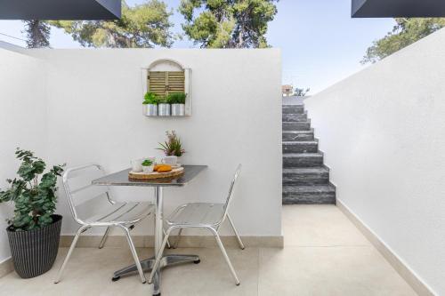 a table and chairs on a patio with stairs at Calm Chaos studio 1 in Kallithea Halkidikis