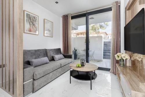 a living room with a couch and a table at Calm Chaos studio 1 in Kallithea Halkidikis