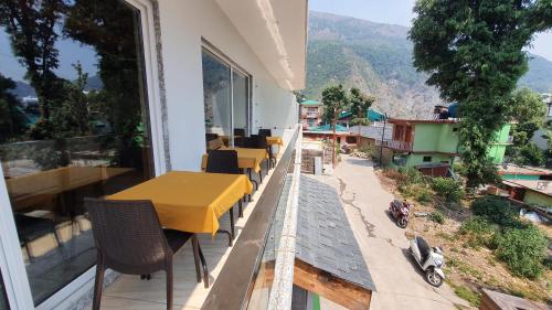 a balcony with a table and chairs and a view of a city at Nomadic Inn in Dharamshala