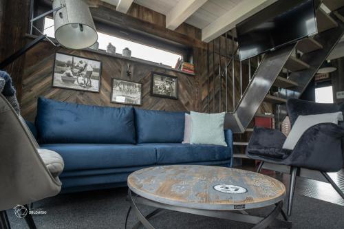 a living room with a blue couch and a table at Szopa in Ustrzyki Dolne