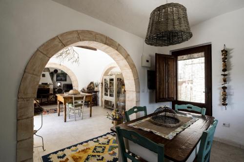諾奇的住宿－Trullo Fragno by Wonderful Italy，一间带拱门和桌椅的用餐室