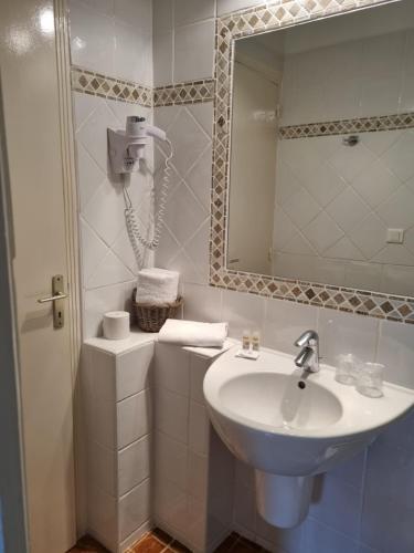 a white bathroom with a sink and a mirror at STELLA MARE in Algajola
