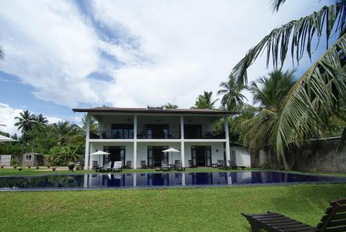 uma villa com piscina e um resort em Nil Menik Villa em Bentota