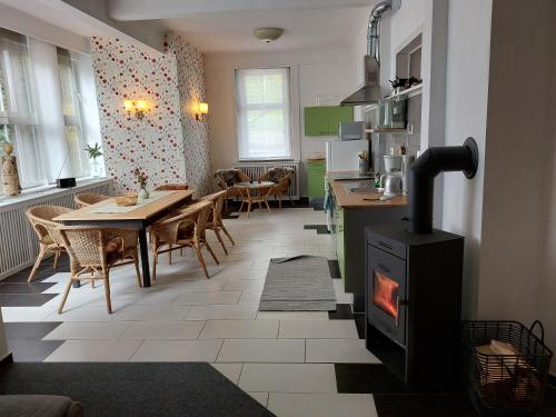 a kitchen and dining room with a stove in a room at Hotel Kapelle Bed & Breakfast in Bad Liebenstein