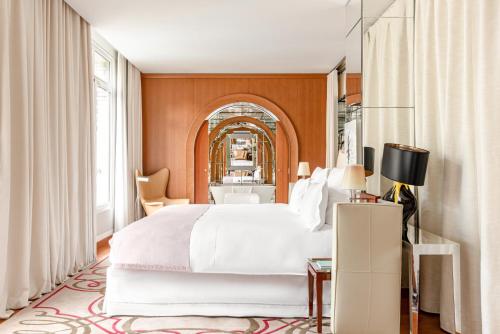 a bedroom with a large white bed and a window at Hôtel Le Royal Monceau Raffles Paris in Paris