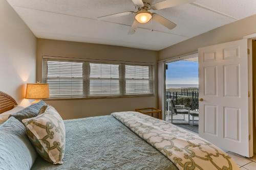 a bedroom with a bed and a ceiling fan at Short Walk to the Beach Condo in Fernandina Beach