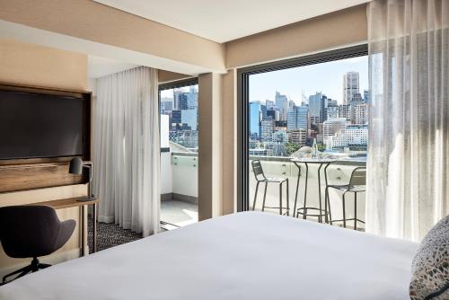 a hotel room with a bed and a view of a city at Aiden by Best Western Darling Harbour in Sydney