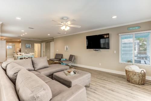 a living room with a couch and a flat screen tv at Beach House w Backyard in Fernandina Beach