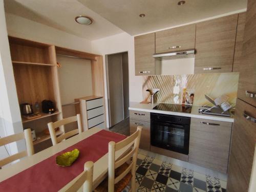 a kitchen with a table and a stove top oven at Logis Le Nid du Pont de Gau in Saintes-Maries-de-la-Mer