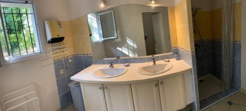 La salle de bains est pourvue de 2 lavabos et d'un grand miroir. dans l'établissement CALME VILLA DANS GOLF - PISCINE PRIVEE SECURISEE, à Montboucher-sur-Jabron
