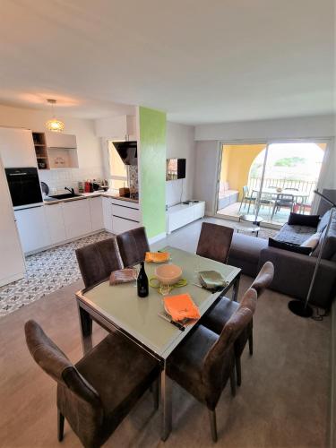 a living room with a table and chairs and a couch at STELLA MARE in Algajola