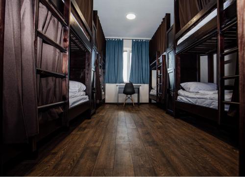 ein Zimmer mit 2 Betten und einem Stuhl darin in der Unterkunft Новый хостел Nesvit Киев Академгородок in Kiew