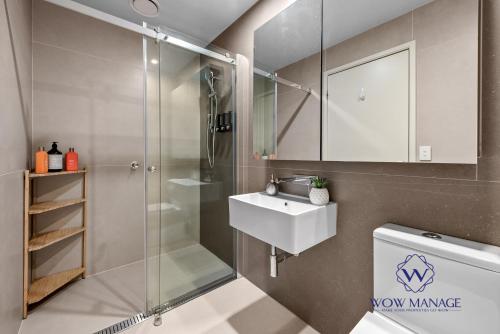 a bathroom with a shower and a sink and a toilet at WOW Apartment on Collins in Melbourne