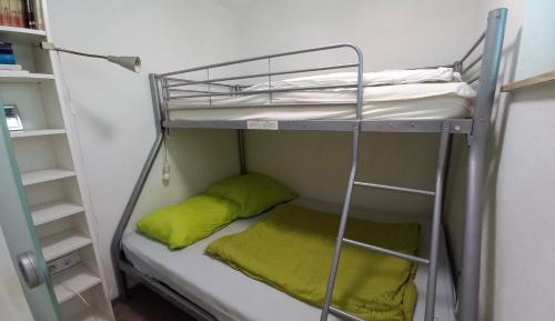 a bunk bed with a green pillow in a room at ANNA Seeblick Appartement, Haus Hänsel&Gretel am Ossiachersee mit direktem Seezugang, Hallenbad in Bodensdorf