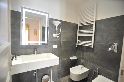 a bathroom with a sink and a toilet and a mirror at La Casa di Nenna in Trentinara