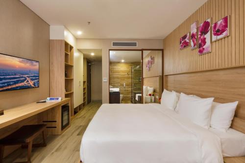 a hotel room with a large bed and a desk at Emerald Bay Hotel & Spa Nha Trang in Nha Trang