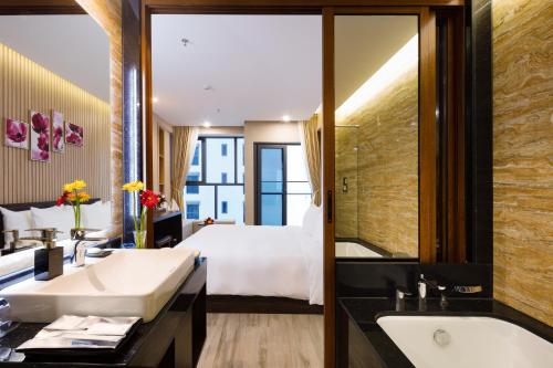 a bathroom with a bed and a sink and a tub at Emerald Bay Hotel & Spa Nha Trang in Nha Trang