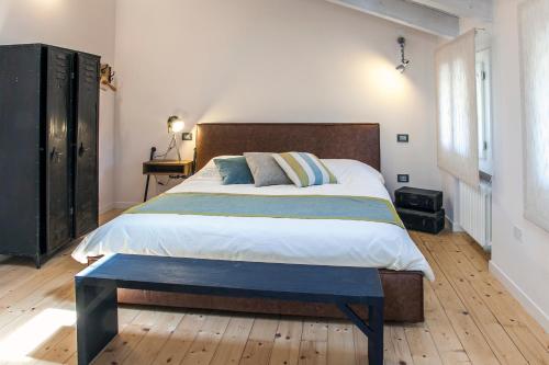 a bedroom with a large bed with a bench on it at El pavejo in Brendola