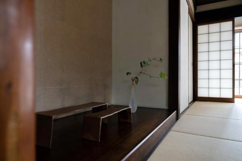 a room with a vase with a plant in it at 滔々 御崎 町家の宿 toutou Onzaki Machiya no Yado in Kurashiki