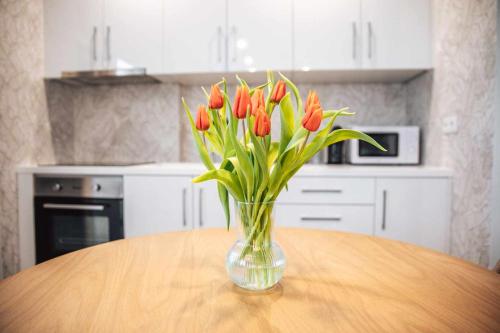 a vase of red tulips sitting on a table in a kitchen at Casa dos Capuchos in Leiria