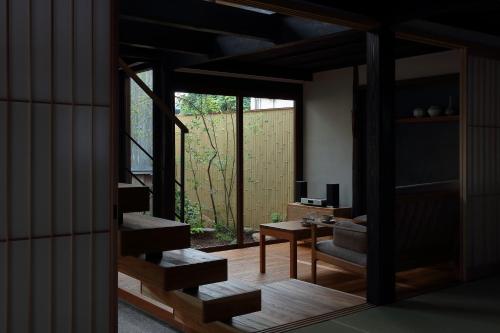 a living room with a table and a large window at 滔々 御崎 町家の宿 toutou Onzaki Machiya no Yado in Kurashiki