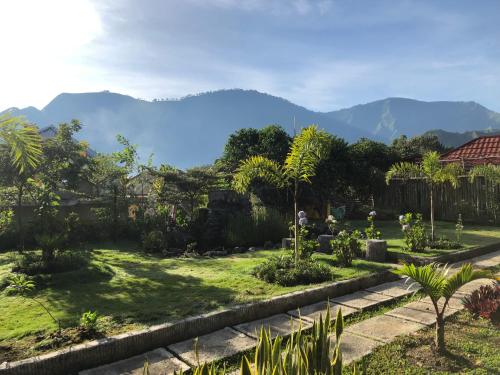 a view of a garden with mountains in the background at Sembalun Kita Cottage in Sembalun Lawang