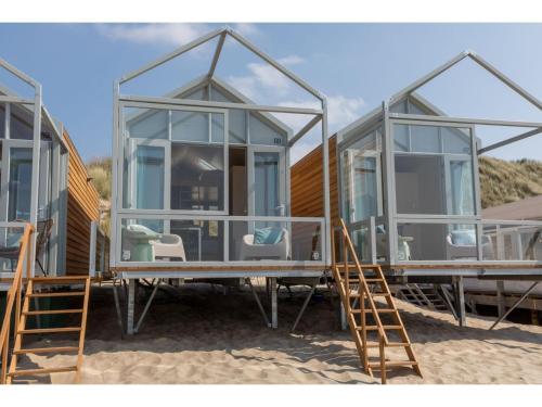 un par de casas de cristal sentadas en la arena en Cottage on the beach of Dishoek, en Dishoek