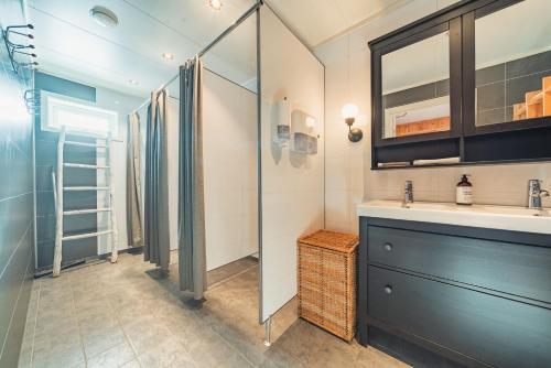 a bathroom with a shower and a sink and a mirror at Holmen Husky Lodge in Alta
