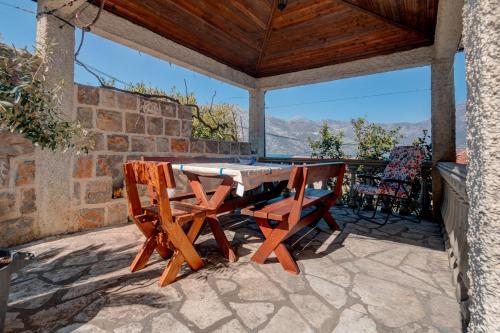 einen Holztisch und Stühle auf einer Terrasse in der Unterkunft La Castagna Apartments in Kotor
