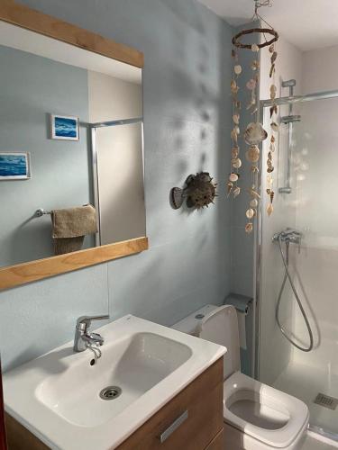 a bathroom with a sink and a toilet and a mirror at Eterna Primavera, a 40m de la piscina natural in Punta Mujeres