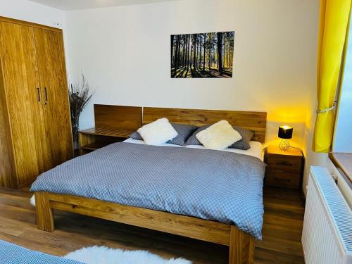 a bedroom with a bed with a wooden head board at Apartmán U Sedmikrásky in Vaclavov u Bruntalu