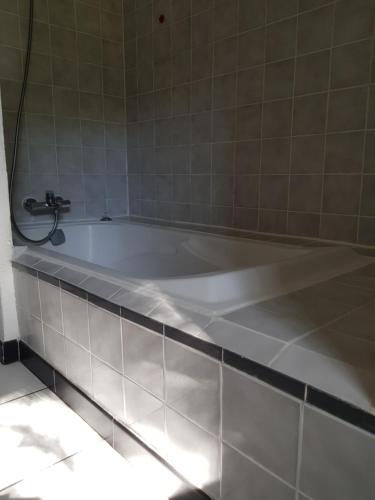 La salle de bains est pourvue d'une baignoire et de carrelage. dans l'établissement La bonne étoile, à Six-Fours-les-Plages