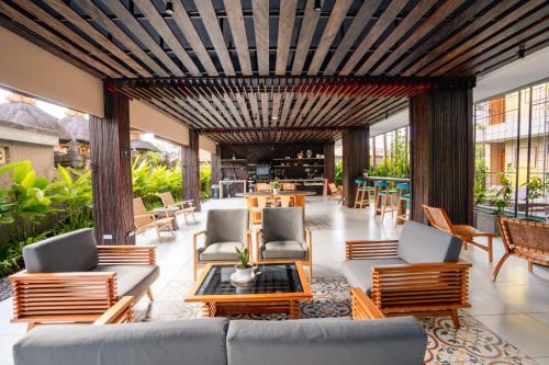 a living room with a couch and chairs and tables at Tanaga CoLiving in Seminyak