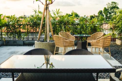 a table and chairs on a patio with trees at Tanaga CoLiving in Seminyak