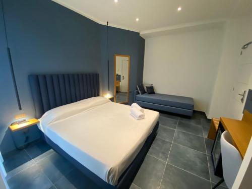 a bedroom with a large white bed and a couch at Hotel Garden in Levanto
