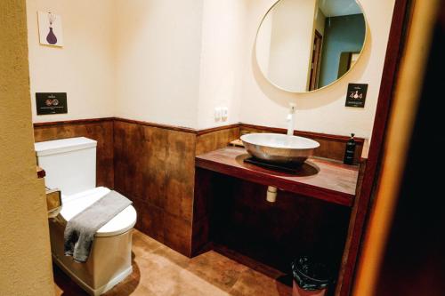 a bathroom with a toilet and a sink with a mirror at Tanaga CoLiving in Seminyak