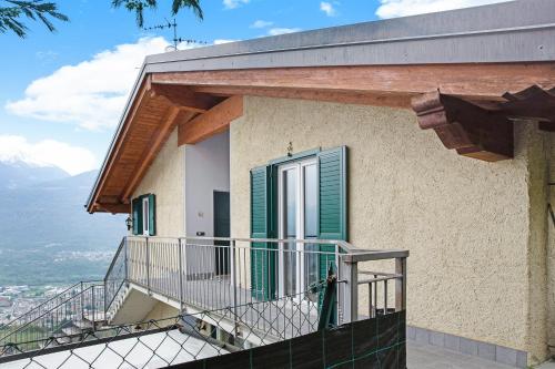 a balcony of a house with green shutters at Casa Vacanze Il Mandala in Sondrio