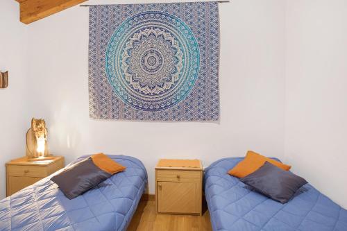a room with two beds and a painting on the wall at Casa Vacanze Il Mandala in Sondrio