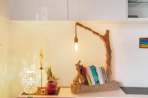 a shelf with books and a lamp on a table at Casa Vacanze Il Mandala in Sondrio