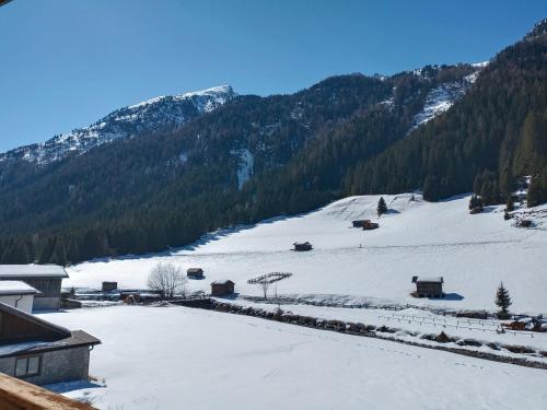a snow covered mountain with houses and trees at Apart Bergglück in Sankt Leonhard im Pitztal