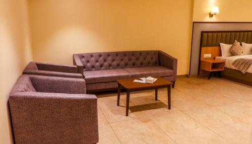 a living room with a couch and a bed at Rudra Shelter Business Hotel in Vasai