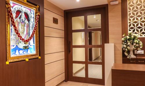 a door in a room with a picture on the wall at Rudra Shelter Business Hotel in Vasai