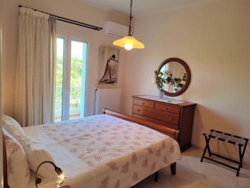 a bedroom with a bed and a mirror and a dresser at Villa Rosemagnolia, pool 35m2, in green, gardens, full sun close to everything in Ayiá