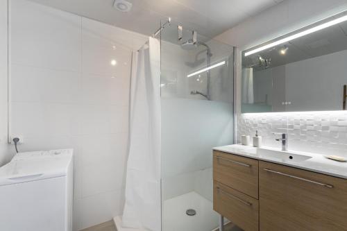 a white bathroom with a shower and a sink at L'Argentine, Maison typique pour 5 a Saint Gilles-croix-de-vie in Saint-Gilles-Croix-de-Vie